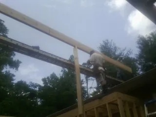 Carpenter setting a ridge beam over a new addition frame — Ice Dam Removal by Roofing Brothers in Glen Spey