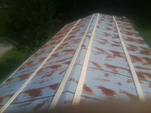 Rusted metal roof panels with new wood purlins before replacement — Storm Damage Roof Repair in Glen Spey by Roofing Brothers