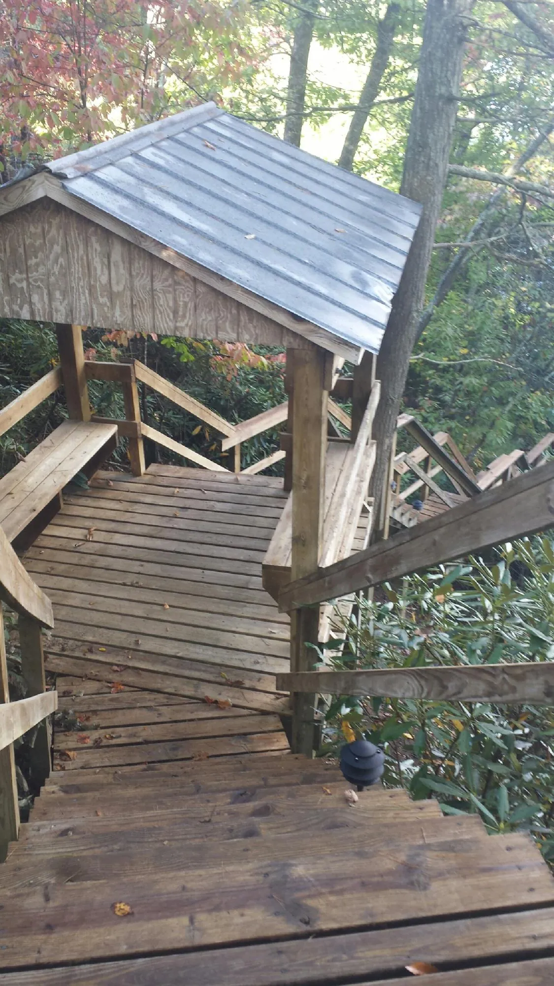Metal roofed shelter over wooden steps on a wooded walkway — Skylight Repair & Installation work by our crew in Glen Spey